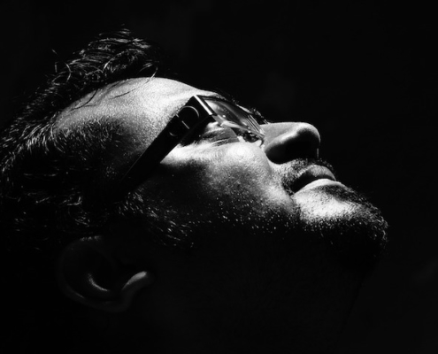 man in glasses looking upward - just his face in shadows