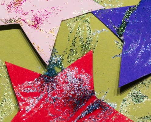 paper stars with glitter tossed over them